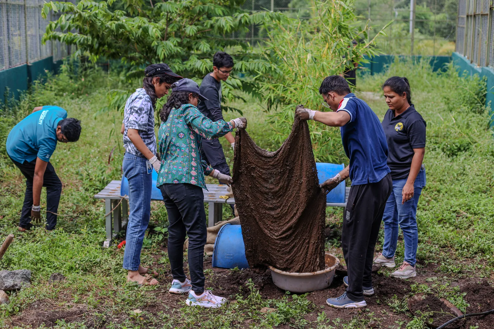 A corporate volunteering team working together outdoors on enclosure enrichment
